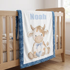 Personalized Highland cow minky baby blanket with Noah's name hanging on wooden crib rail