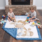 Personalized Highland cow minky baby blanket laid on floor as two boys play beside the fireplace