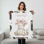 Woman holding personalized highland cow minky blanket with cow print trim on couch