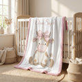 Personalized highland cow minky blanket with pink trim draped over white crib rail