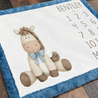 Close-up of personalized horse milestone blanket corner with blue faux fur trim