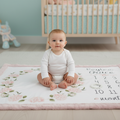 Baby sitting on personalized hydrangea milestone minky blanket with pink trim in nursery