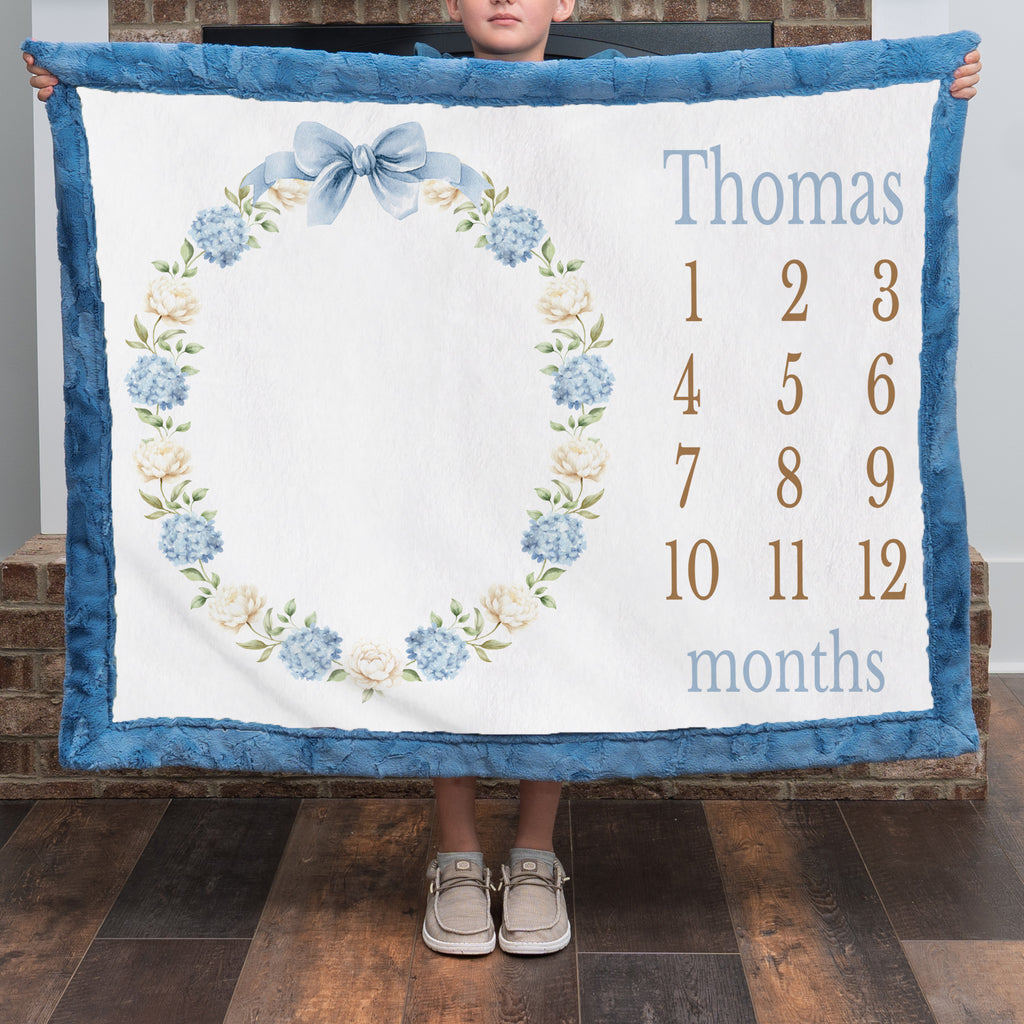 Personalized milestone minky blanket with hydrangea wreath held up close by child