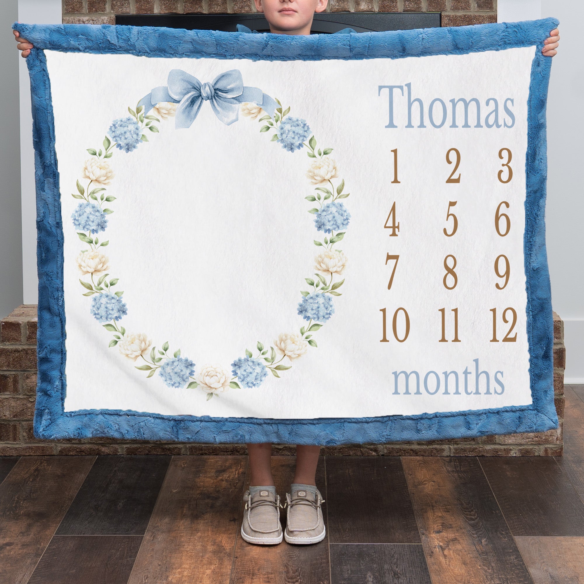 Personalized milestone minky blanket with hydrangea wreath held up close by child