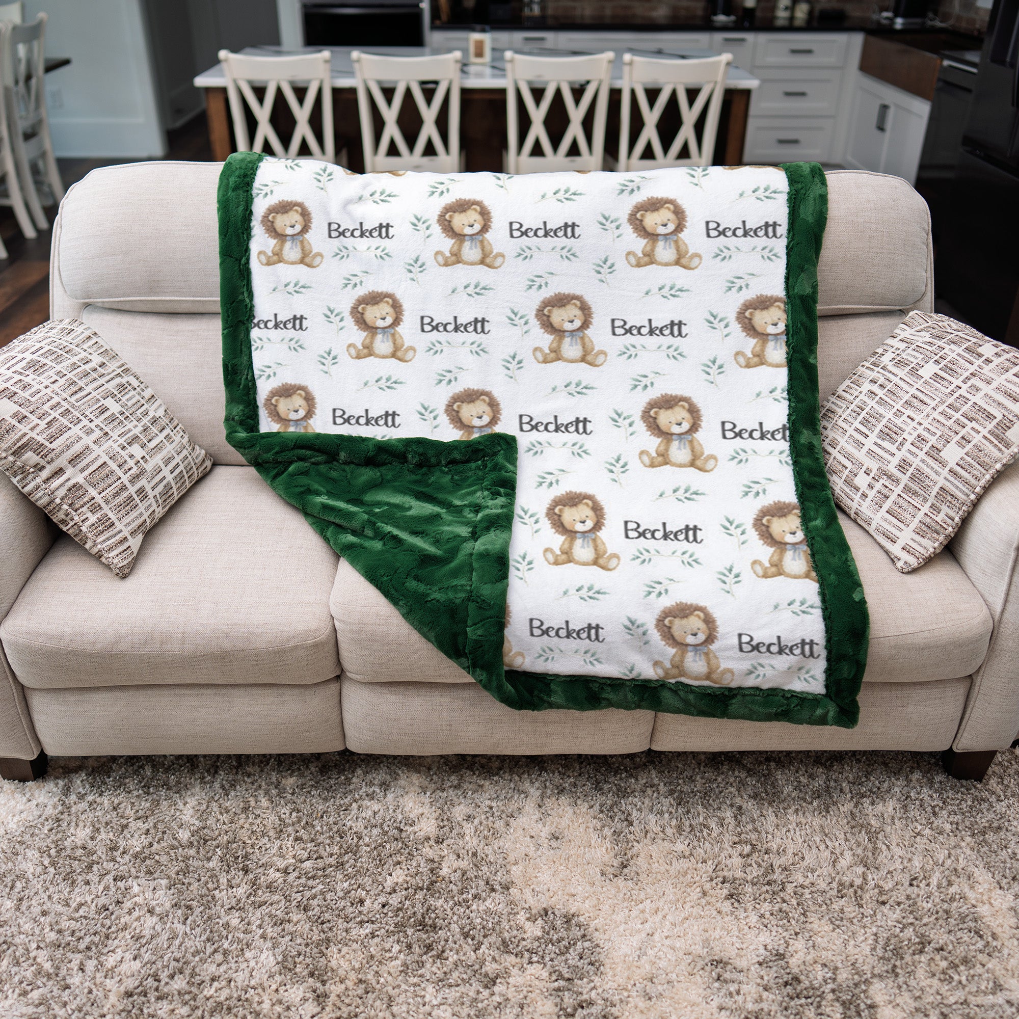Personalized minky lion baby blanket with green fur border draped over couch, minky back showing