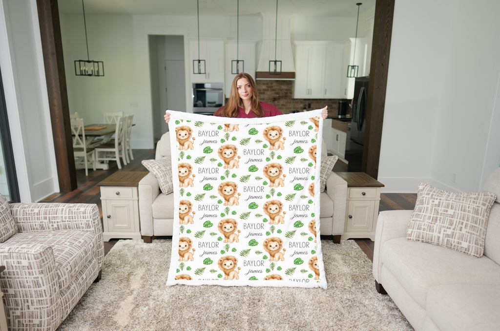 Woman holding personalized lion baby blanket with white minky trim in open-concept kitchen