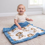 Baby seated on carpet with personalized lion print minky blanket draped over lap
