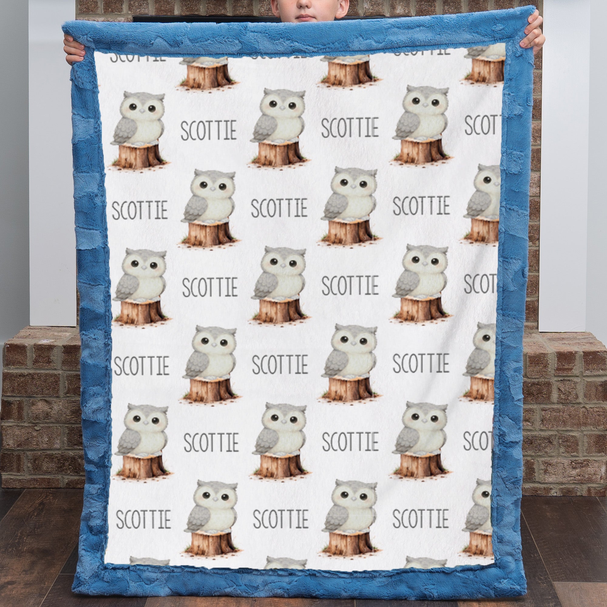 Boy holding personalized owl minky blanket with blue trim