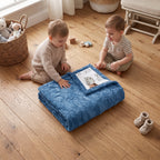 Two boys sitting with folded personalized owl minky blanket, blue trim, in nursery