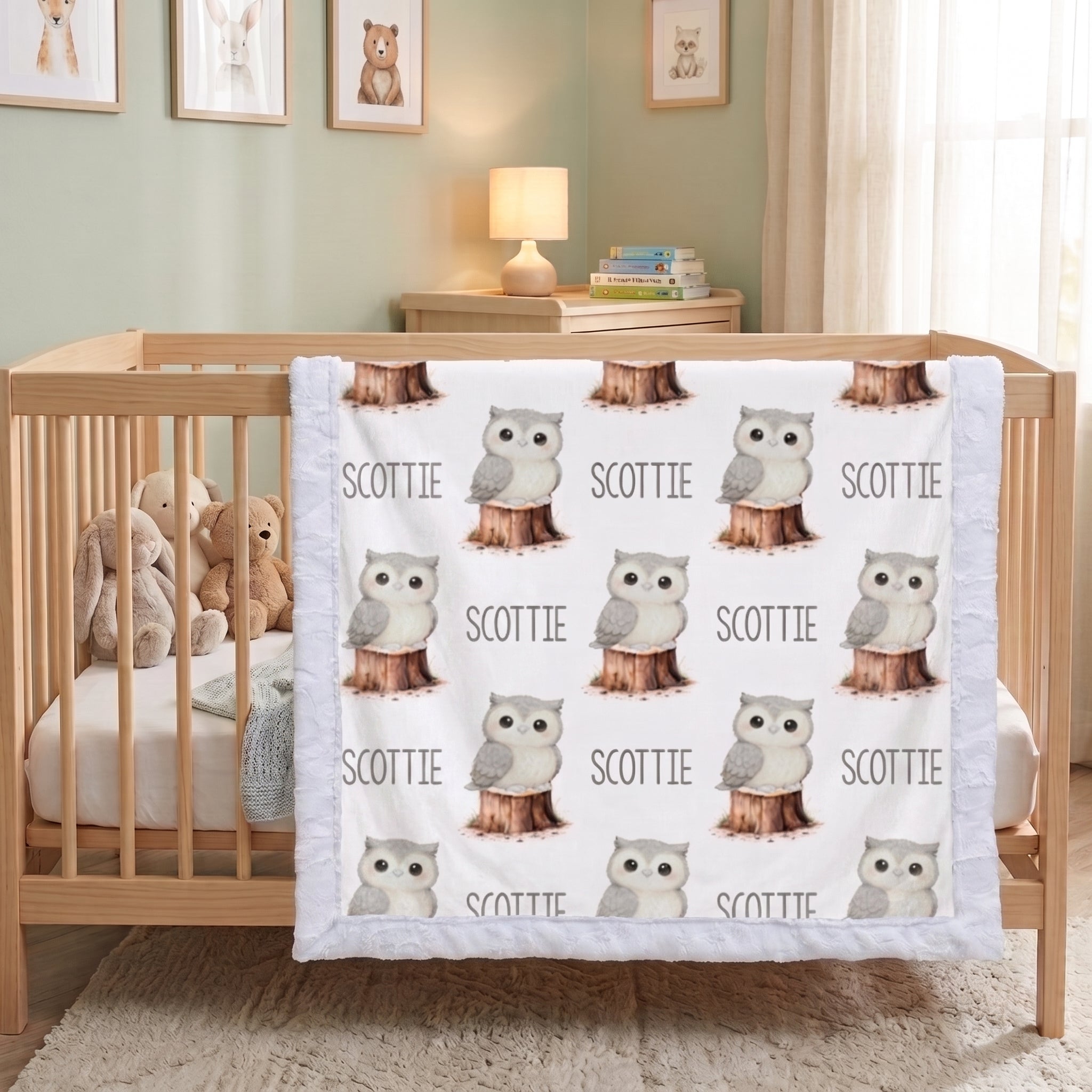 Personalized owl minky blanket with white sherpa back draped over crib rail