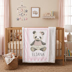 Personalized minky panda baby blanket draped over wooden crib in boho nursery