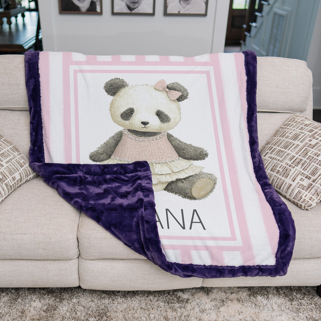 Personalized minky panda baby blanket with purple minky back draped over couch