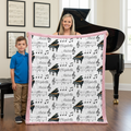 Mother and son holding personalized piano minky blanket with pink trim near a grand piano