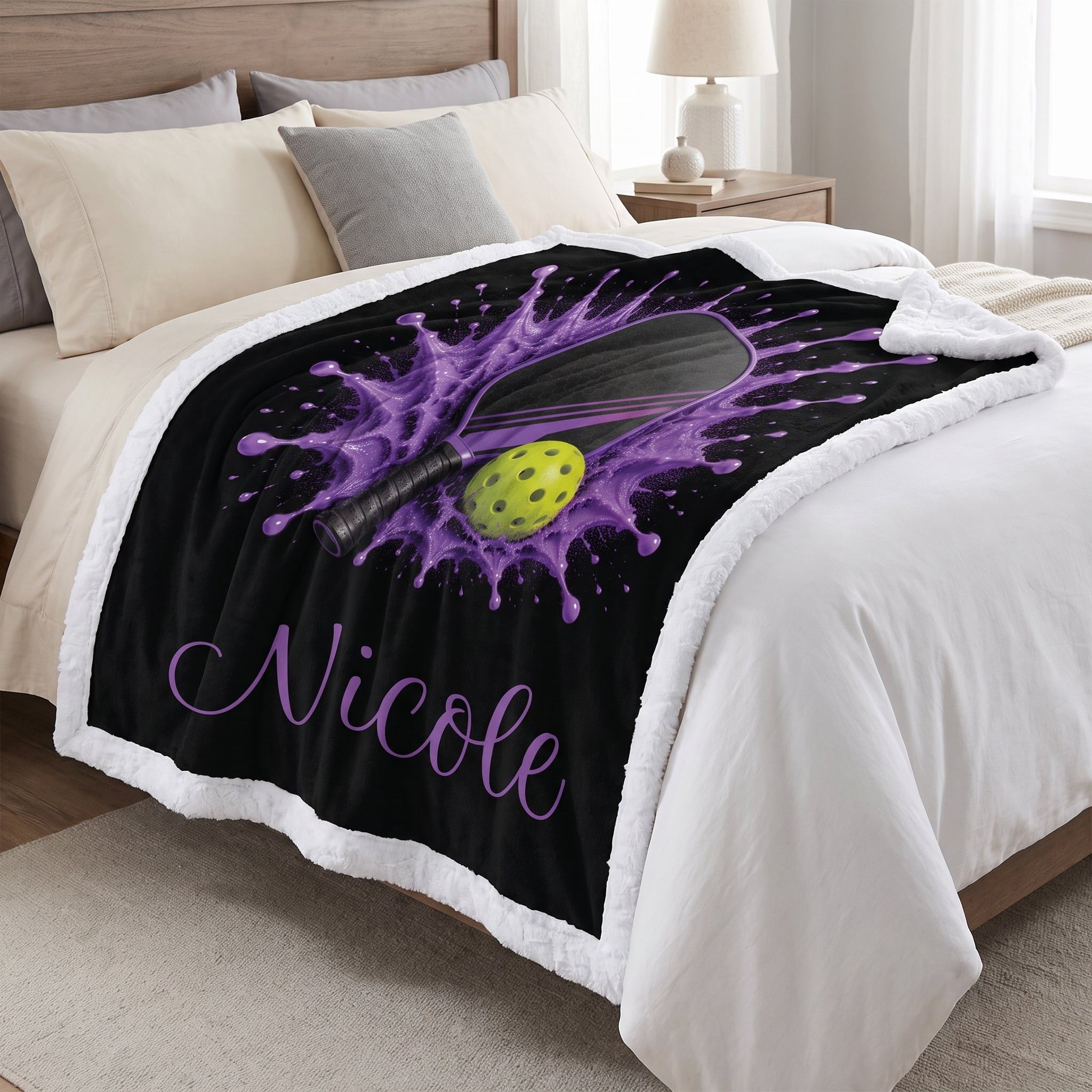 Purple pickleball blanket with plush white backing and personalized name Nicole, laid on a bed