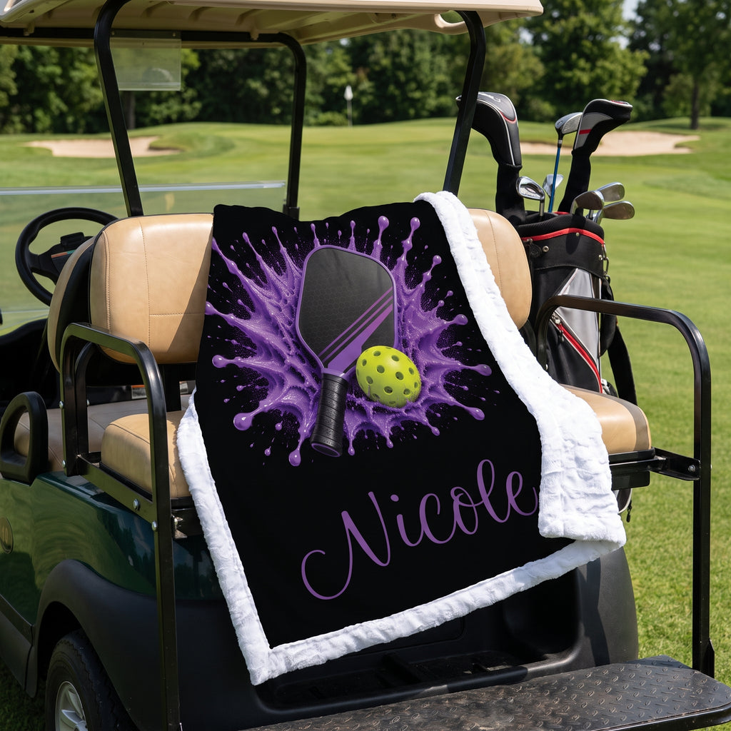 Personalized purple pickleball blanket with name Nicole draped over a golf cart seat