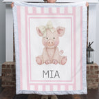 Personalized Luxe Cuddle Minky pig baby blanket with pink stripe border held up by fireplace