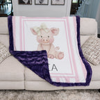 Personalized Luxe Cuddle Minky pig baby blanket with purple back draped over couch
