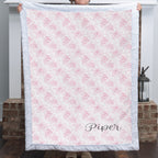 Personalized pink floral minky blanket displayed in front of white fireplace mantel