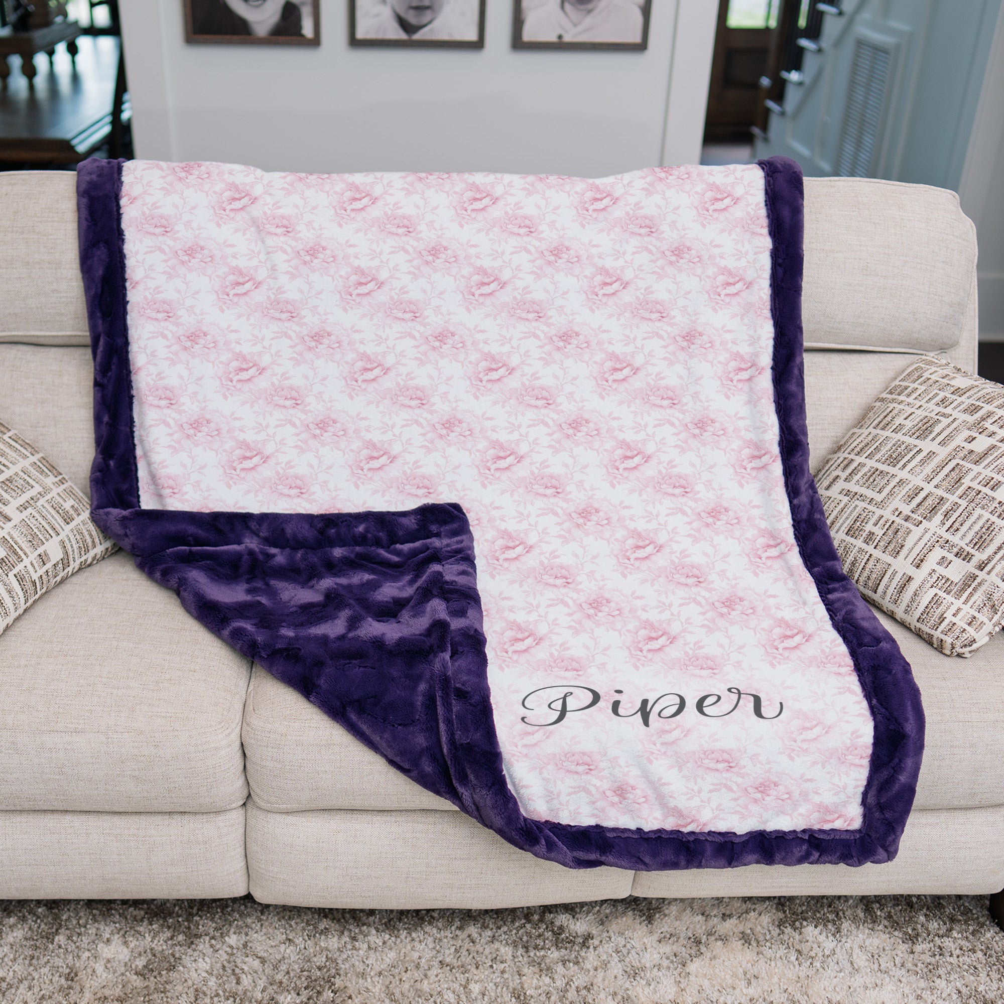 Personalized pink floral minky blanket with plum faux fur trim draped over couch
