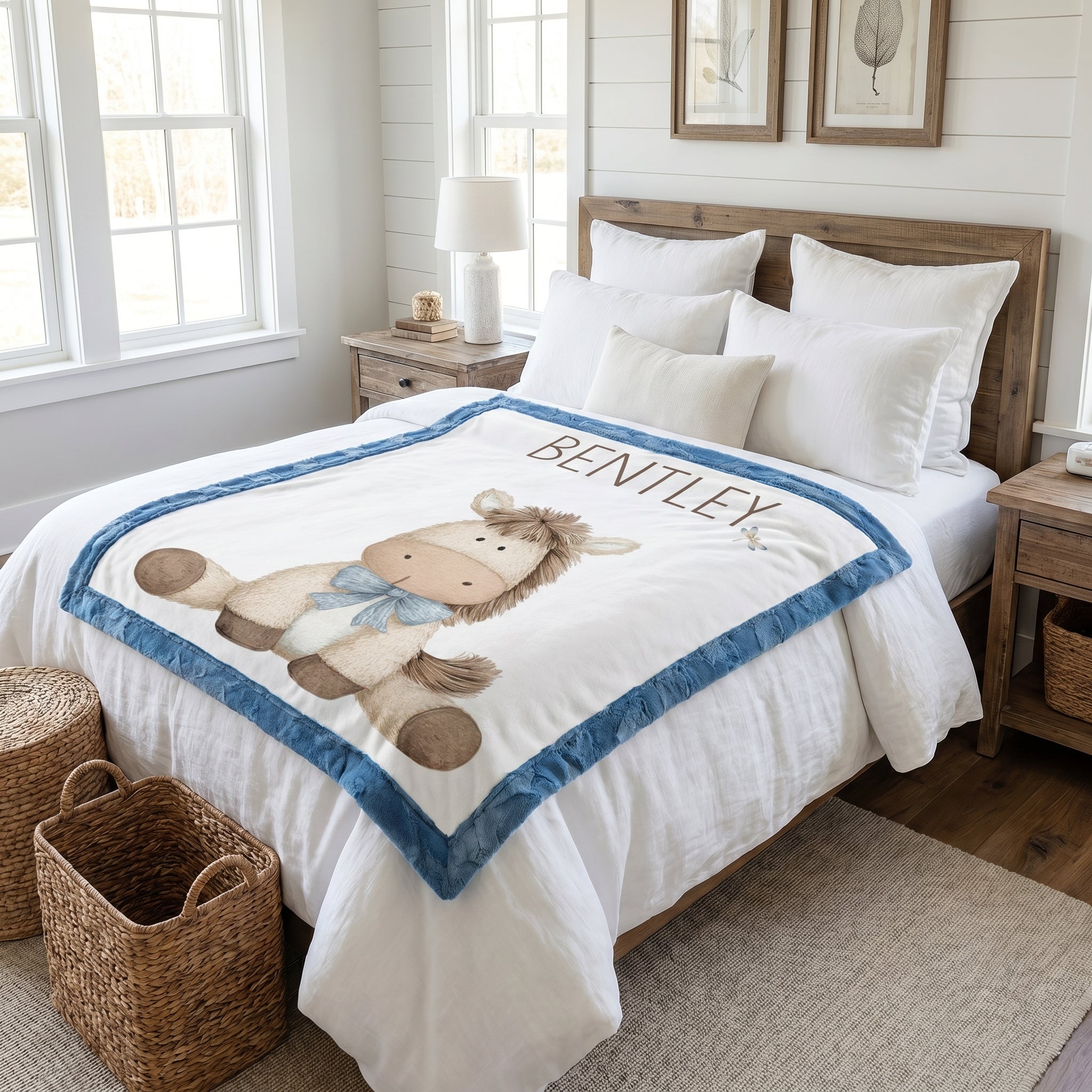 Personalized pony baby blanket with blue minky trim draped over white bed