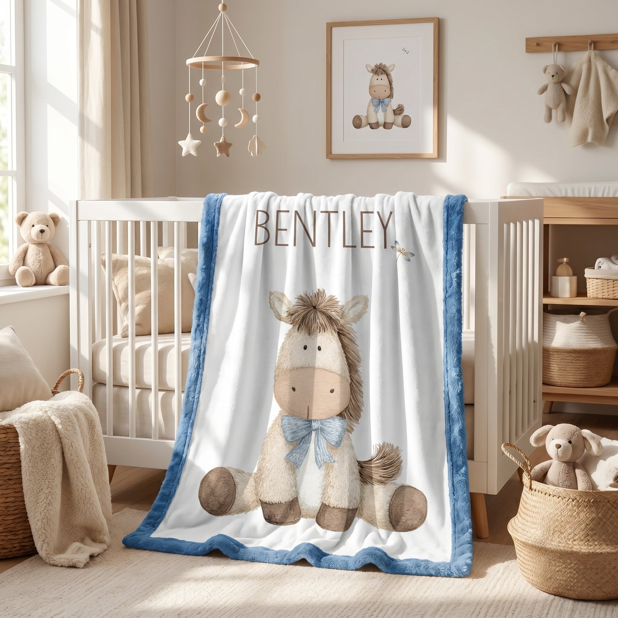 Personalized pony baby blanket with blue minky trim draped over nursery crib