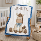 Personalized pony baby blanket with blue minky trim draped over wooden nursery rocking chair