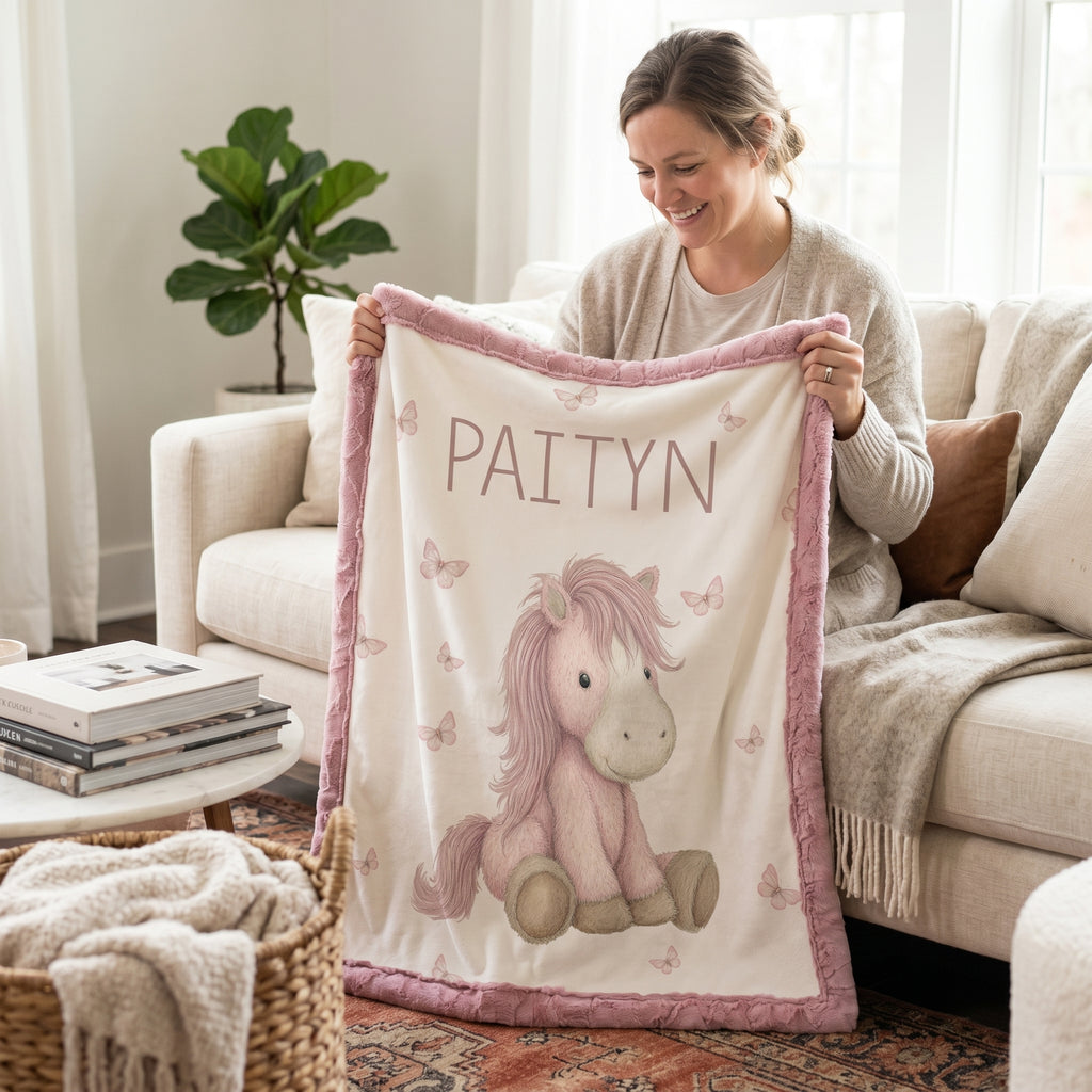 Woman holding personalized pony baby blanket with pink minky trim in living room