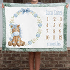 Personalized pony milestone minky blanket with sage trim held up outdoors
