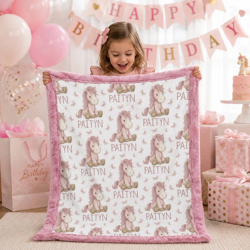 Girl holding personalized pony name blanket with pink minky trim at birthday party
