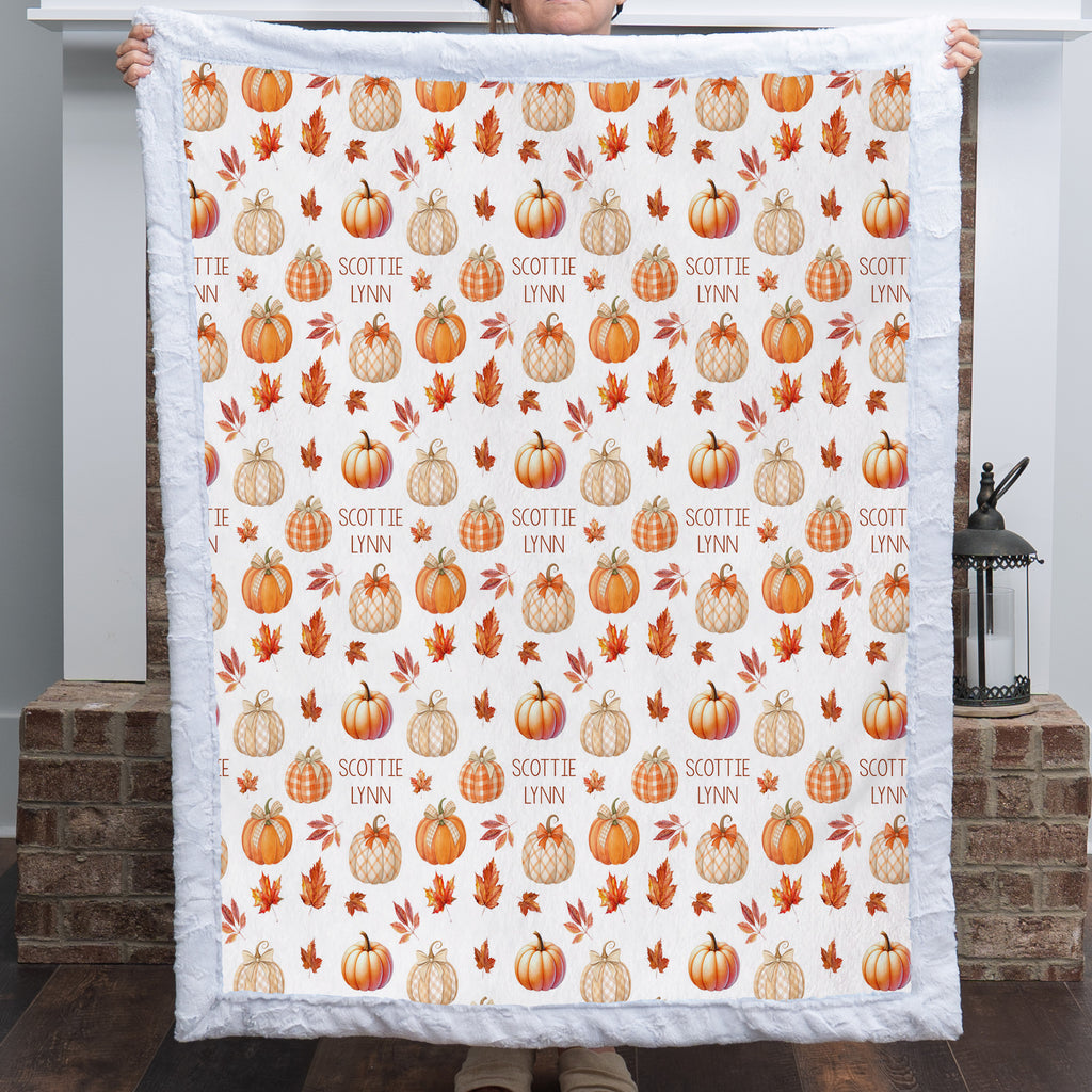 Woman holding personalized pumpkin patch minky blanket with custom name, white faux fur trim