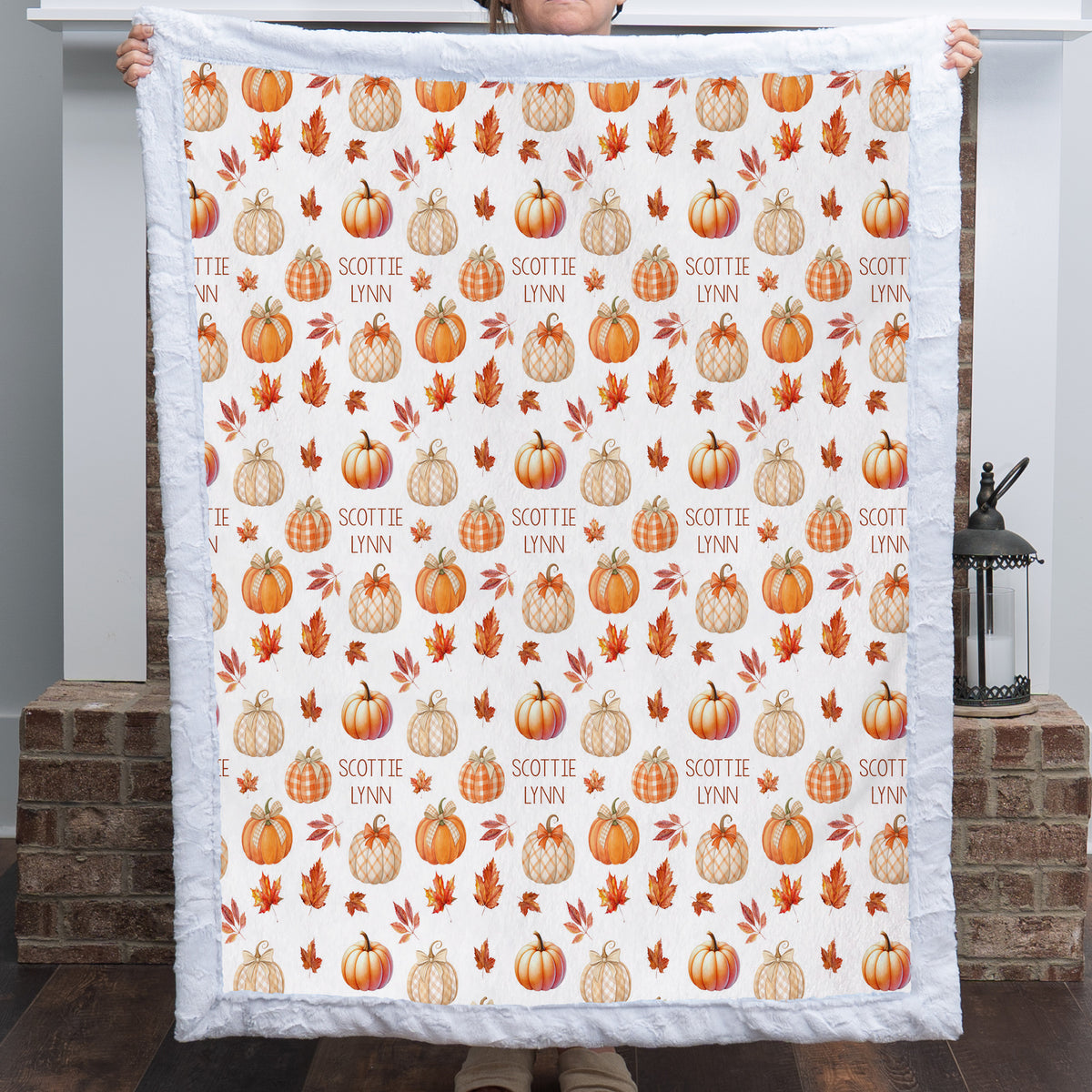 Woman holding personalized pumpkin patch minky blanket with custom name, white faux fur trim
