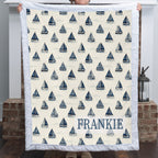 Personalized sailboat minky blanket with FRANKIE name held up by fireplace