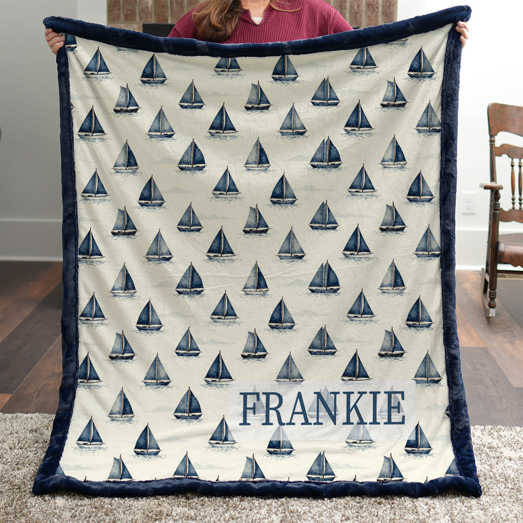 Woman holding personalized sailboat minky blanket with FRANKIE name indoors