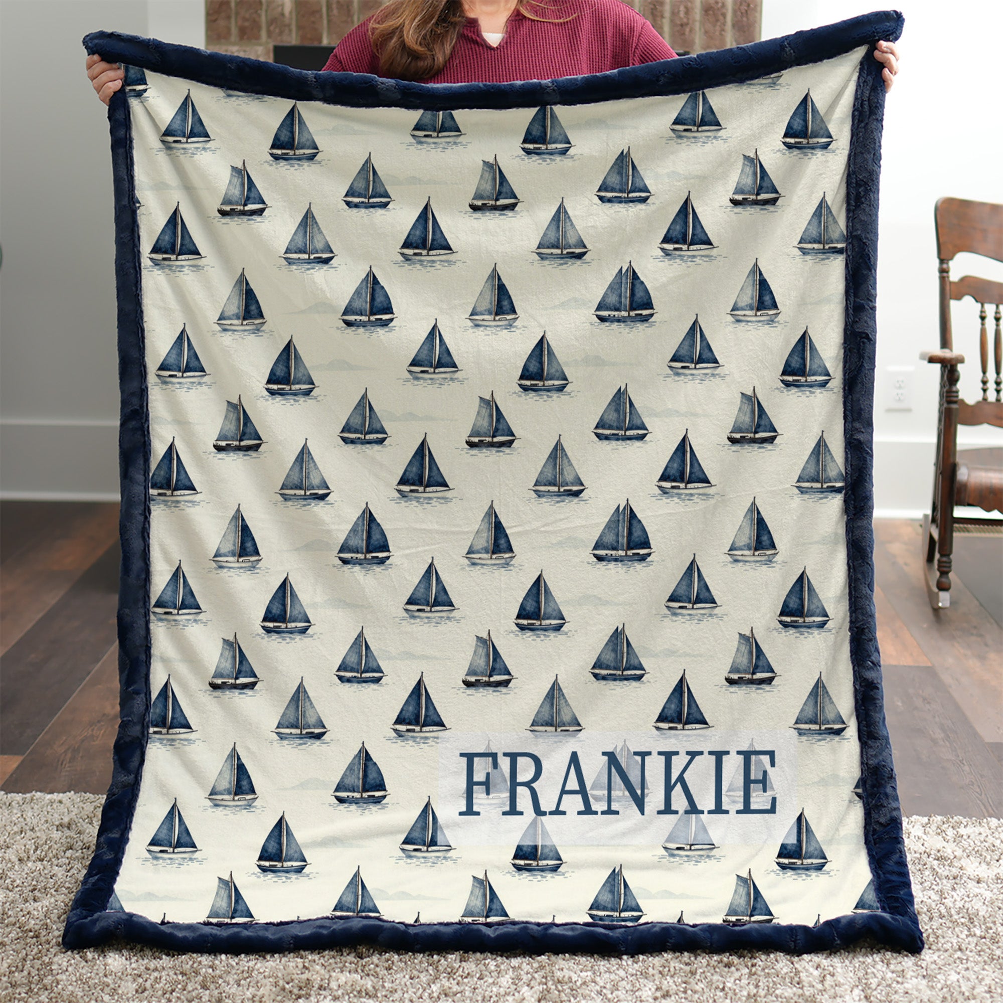 Woman holding personalized sailboat minky blanket with FRANKIE name indoors