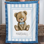 Child holding personalized minky teddy bear baby blanket with blue fur border by brick wall
