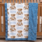 Personalized teddy bear minky baby blanket draped over a wooden crib rail in nursery