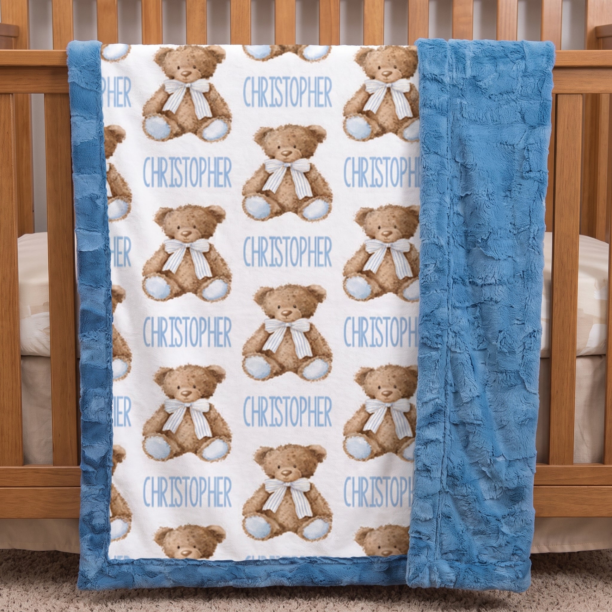 Personalized teddy bear minky baby blanket draped over a wooden crib rail in nursery