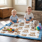 Personalized minky baby blanket laid flat with two boys and toys, teddy bear print with blue trim