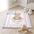 Personalized minky teddy bear baby blanket flat-lay on nursery floor with stuffed animals