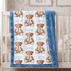 Personalized minky baby blanket with teddy bear print hanging on white crib rail in nursery