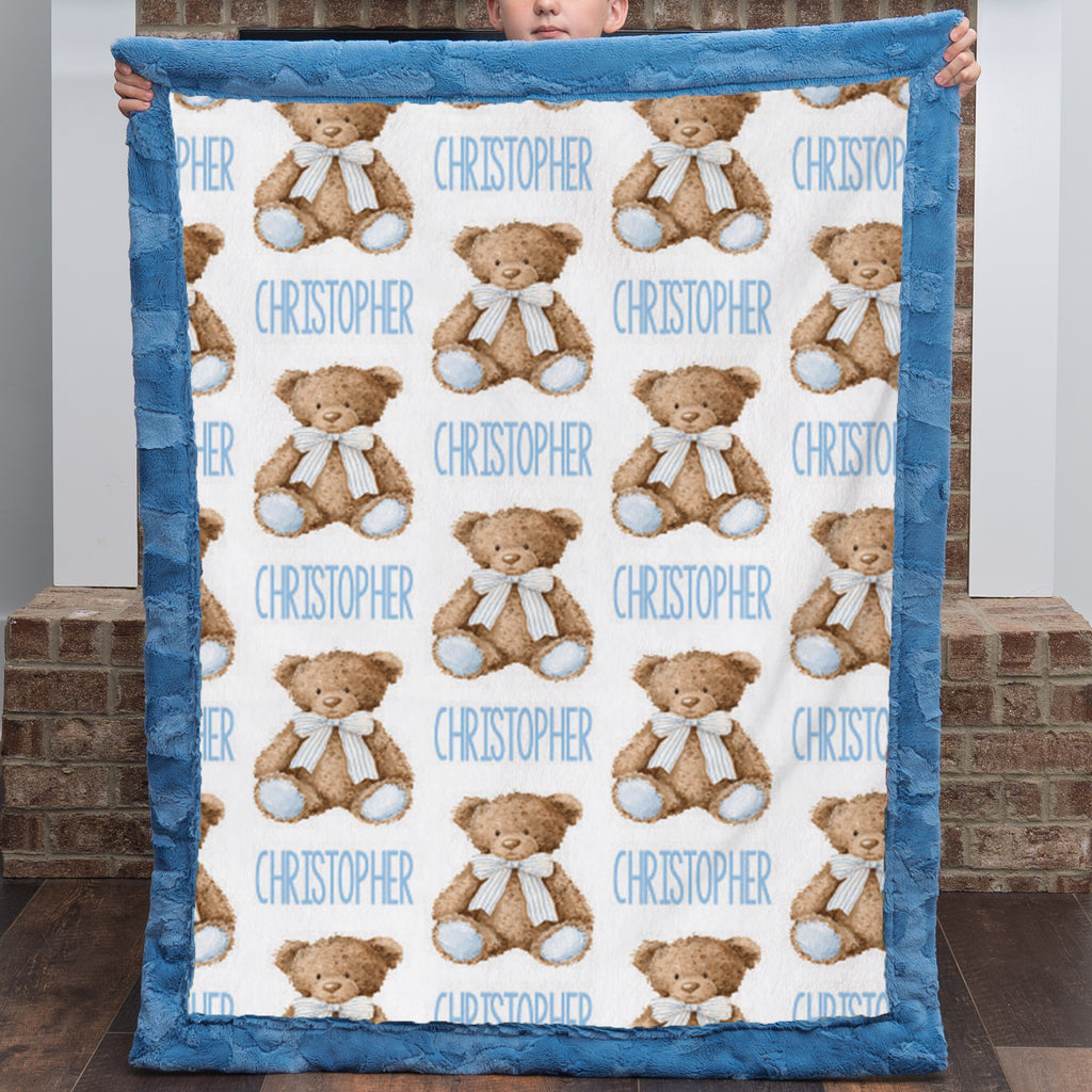 Personalized teddy bear minky baby blanket held up by a child, name printed throughout the pattern