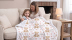 Mother and toddler holding personalized teddy bear minky baby blanket with Isabella name on couch