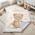 Personalized Isabella teddy bear minky baby blanket laid on nursery rug, corner flipped to show blue minky backing