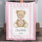 Personalized minky teddy bear baby blanket with pink rosette fur border by fireplace mantel
