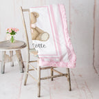 Personalized minky teddy bear baby blanket with pink rosette fur border on vintage chair