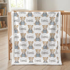 Personalized teddy bear minky baby blanket with white fur border draped over wooden crib in nursery
