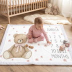 Baby girl sitting on personalized teddy bear milestone blanket with white minky trim