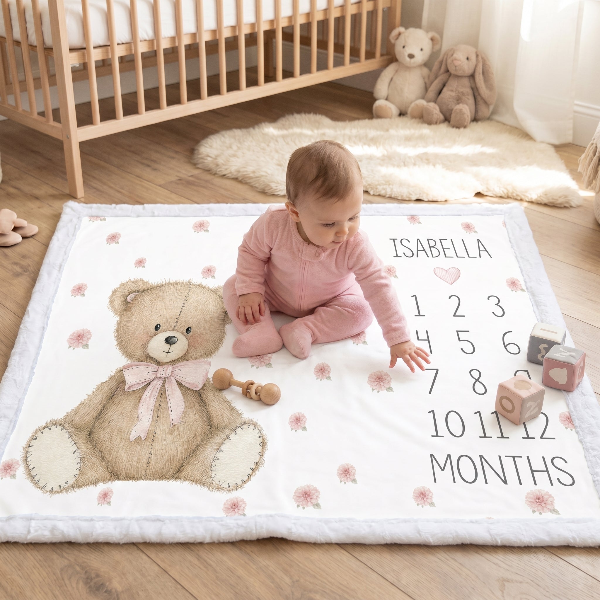 Baby girl sitting on personalized teddy bear milestone blanket with white minky trim