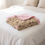 Personalized western horse blanket folded on bed, pink rosette faux fur trim