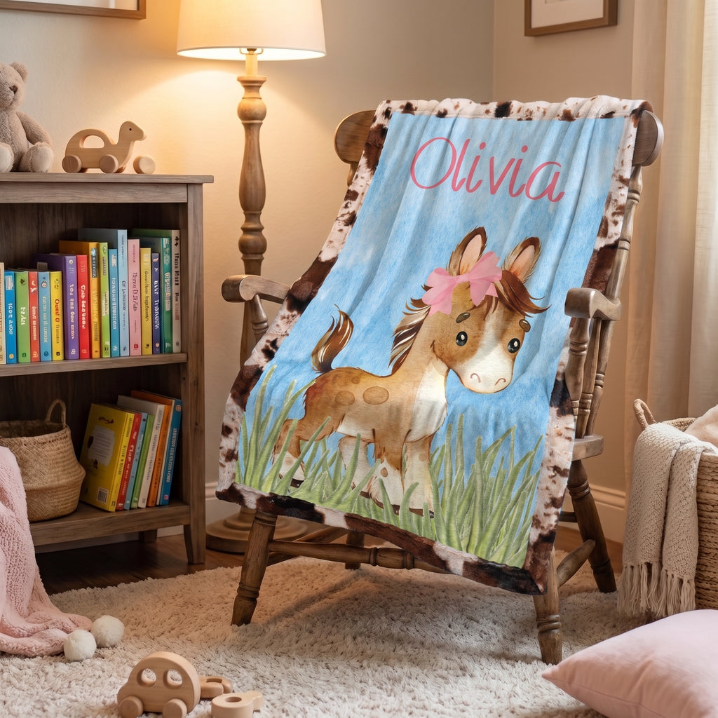 Personalized western pony minky baby blanket with cowhide border on wood nursery rocking chair